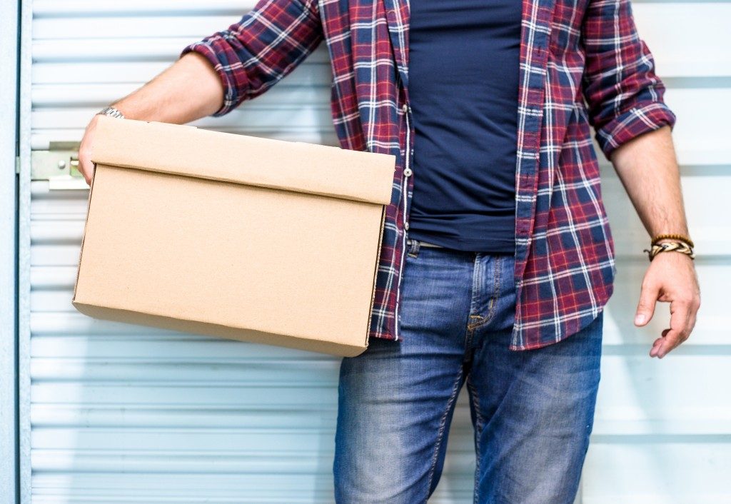 man holding a box in a garage background