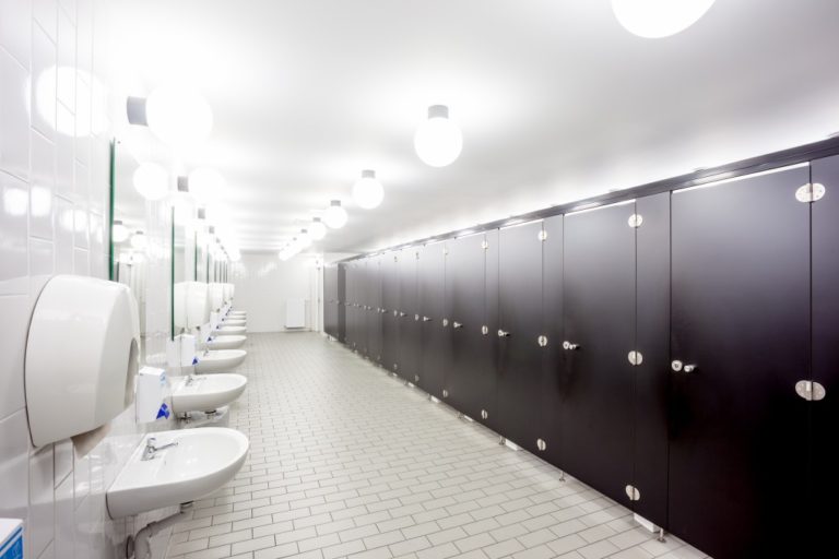 wide office washroom in white and brown color interior