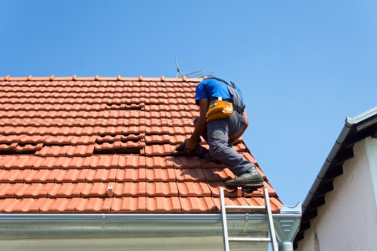 A man fixing the roof on a sunny day