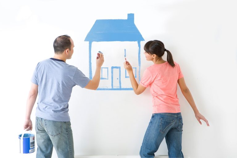 couple painting a house on the wall